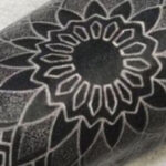 White ink tattoo on arm