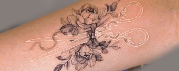 White ink tattoo on the shoulder