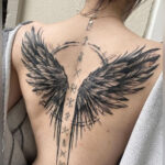 Detailed realistic angel wing tattoo on a woman's back, symbolizing protection and guidance