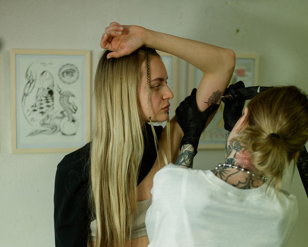 Woman wearing a loose button-up shirt, ideal for shoulder tattoo access.