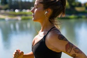 women running in the sun with tattoos and sunscreen