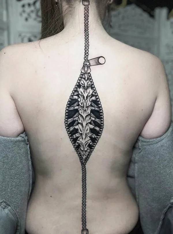 Unique spine tattoo resembling a zipper, created by @t_bag_tattz