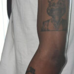An arm of a Kanye West fan showing My Beautiful Dark Twisted Fantasy tattoo art