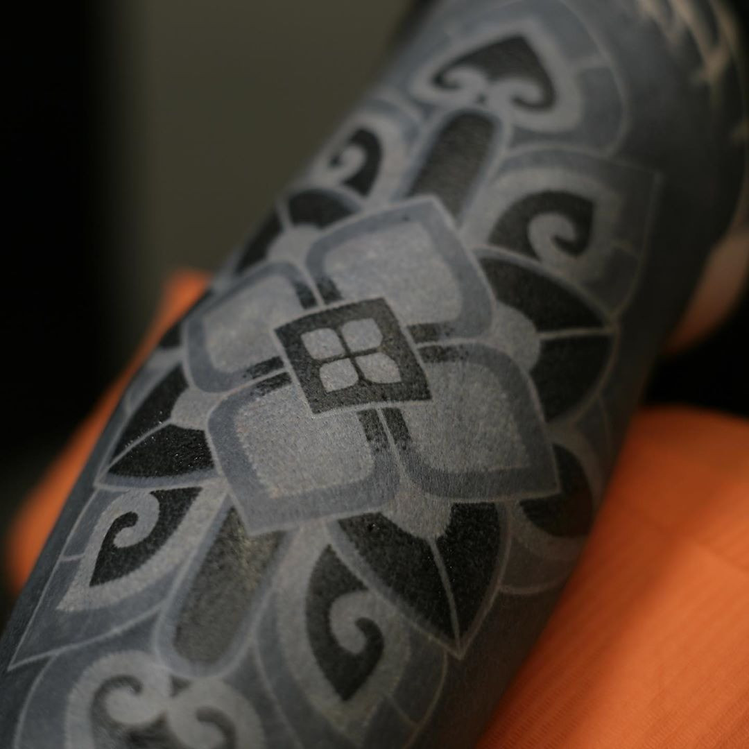 A close-up of a tattoo artist using organic, non-toxic black ink, emphasizing safety and quality in the tattooing process