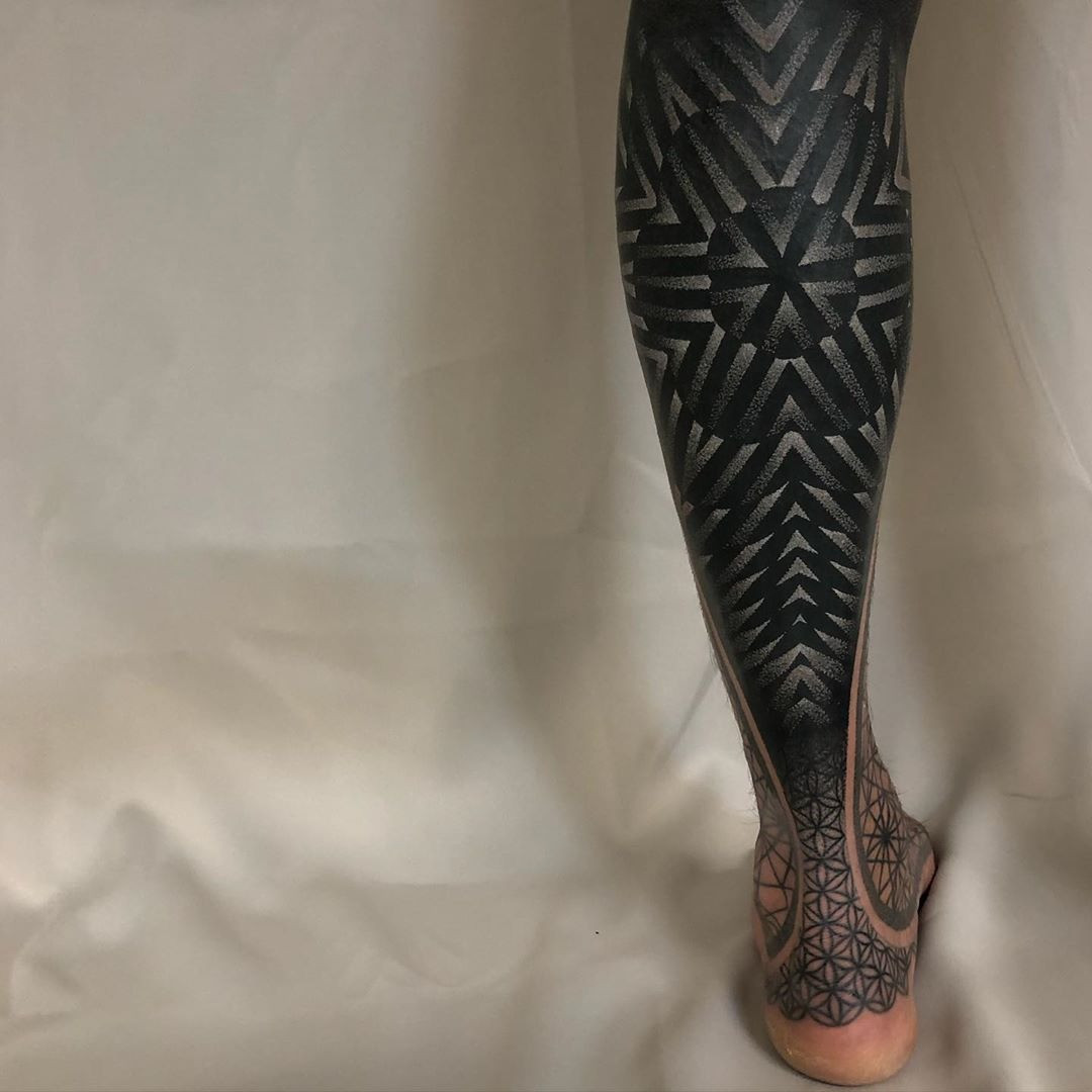 Close-up of the white-out technique in progress, showing white ink being layered over an existing tattoo to lighten it