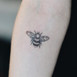 A simple forearm tattoo of a bird taking flight, symbolizing freedom and new beginnings