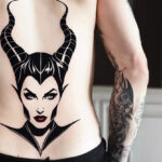 A man showcasing a Maleficent outline tattoo on his lower back, a subtle nod to the Disney antagonist