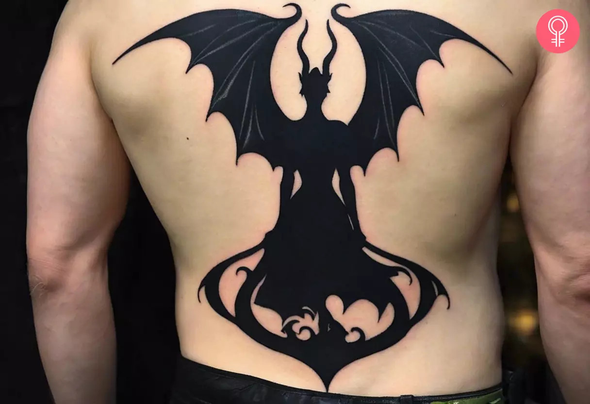 A man proudly displaying a silhouette Maleficent tattoo on his back, a tribute to the misunderstood fairy
