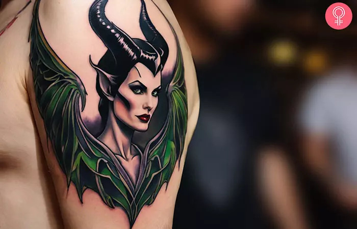 A man showing off a Maleficent wings tattoo on his upper arm, symbolizing freedom and self-protection