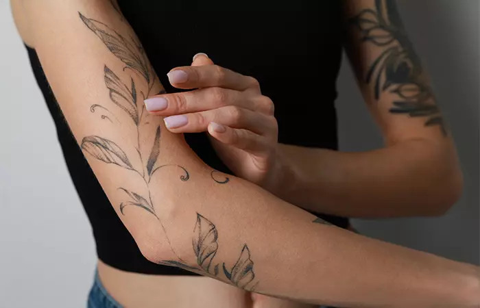 Woman applying aloe vera on a fresh tattoo, showcasing the soothing and healing properties of aloe vera for tattoo aftercare.