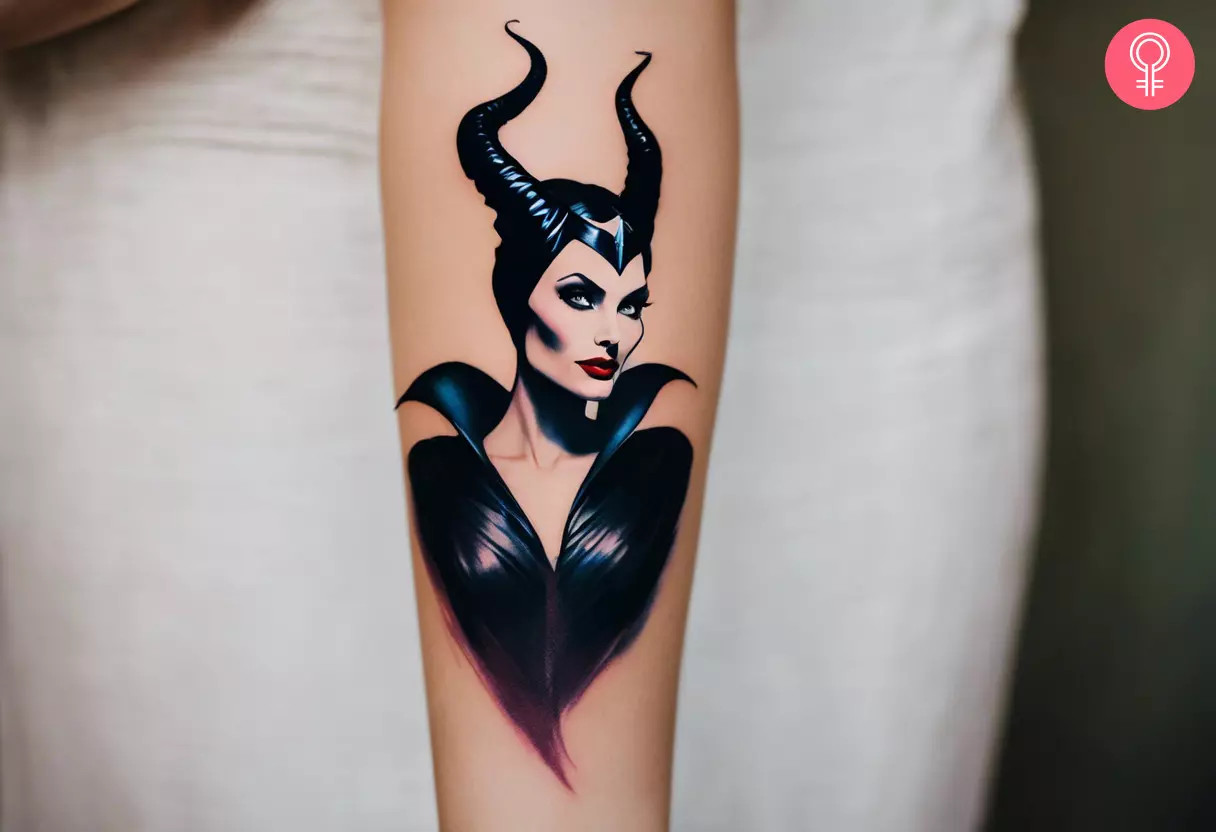 A woman showcasing a Maleficent tattoo on her lower arm, a charming blend of beauty and darkness