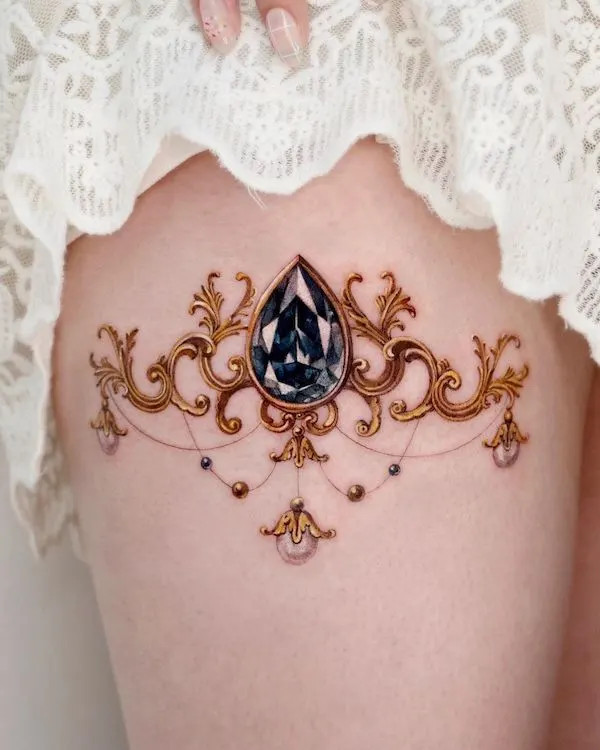 Gold frame and gemstone tattoo on the thigh, by @chou_ta_1, creating a luxurious and unique adornment