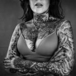 Singer Acid's Tattoo by Robert Hellstrom, showcasing a black and white portrait that captures the raw emotion and deep connection she has with her body art.