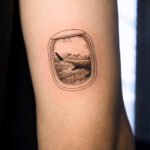 aeroplane window view showing clouds wing tattoo female tricep