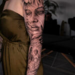 Intricate sleeve tattoo featuring detailed floral and animal designs