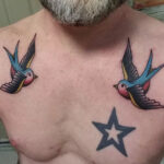 Stylized bird tattoo perched on the collarbone