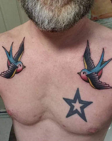 Stylized bird tattoo perched on the collarbone