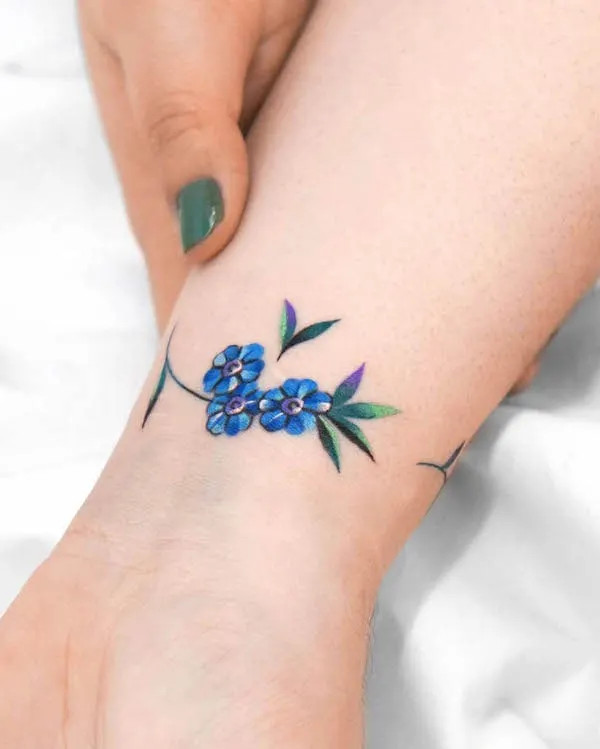 Detailed blue floral bracelet tattoo by @eden_tattoo_