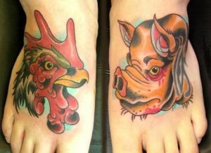 A pig and rooster tattoo on a foot, symbolizing protection against shipwrecks and drowning, a traditional nautical charm with roots in maritime folklore.