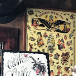 A close-up of a tattoo artist's hand holding a wad of cash, symbolizing the cash-only preference in many tattoo parlors.