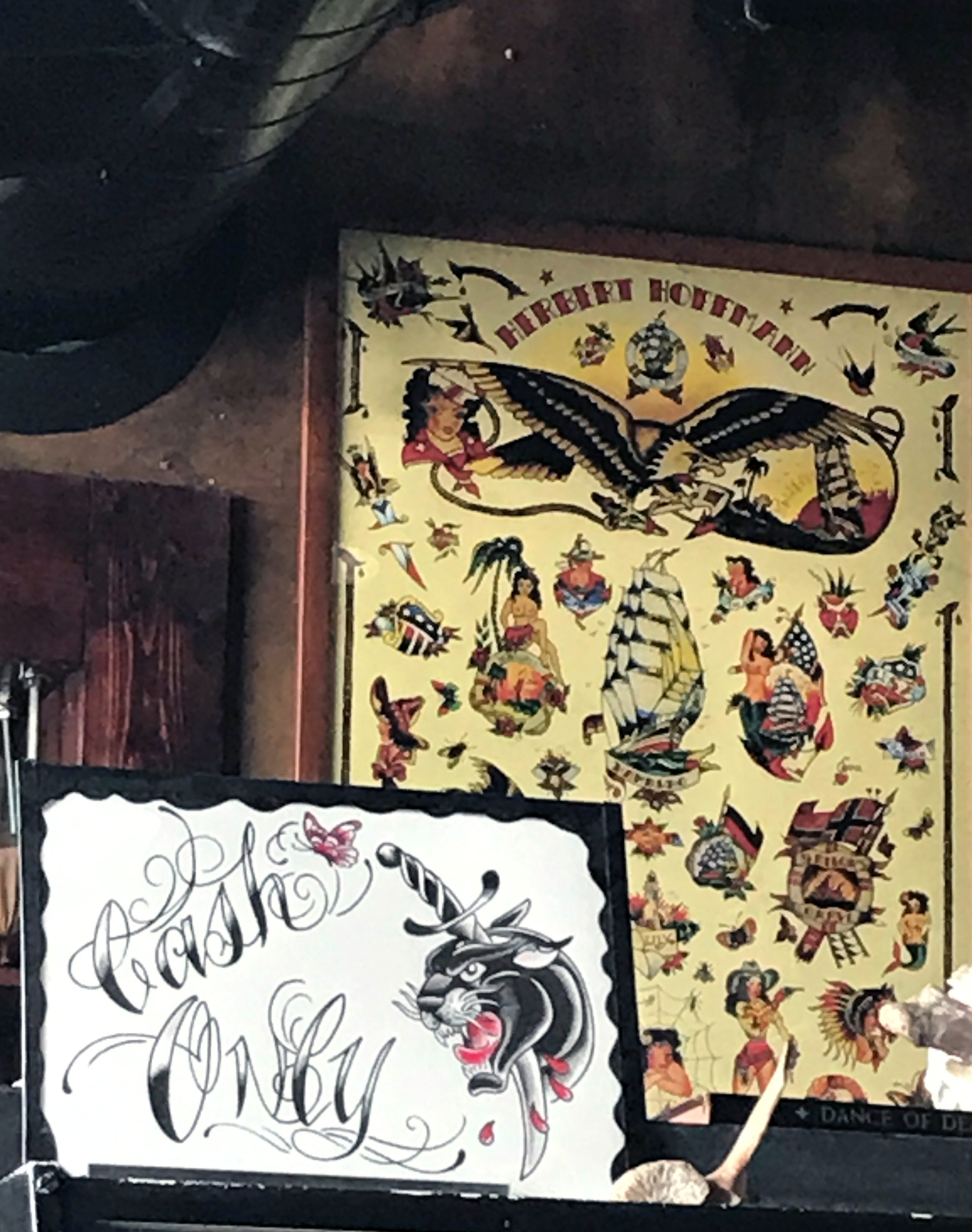 A close-up of a tattoo artist's hand holding a wad of cash, symbolizing the cash-only preference in many tattoo parlors.