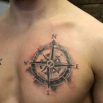 Subtle chest tattoo of a compass rose for men
