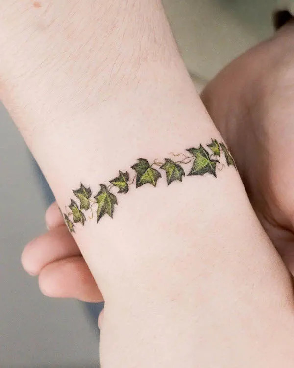 Colorful leaves bracelet tattoo on wrist for women by @zihong_tattoo