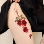 Vibrant red roses tattoo on the upper thigh, symbolizing love and passion, by @peria_tattoo