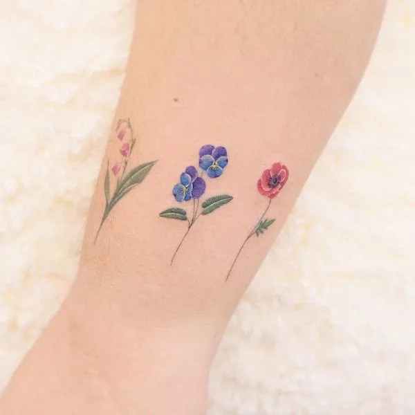 Cute flowers around the wrist bracelet tattoo by @siyeon_tattoo