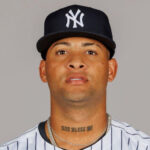 Luis Gil's neck tattoo with the words GOD BLESS ME prominently displayed, symbolizing his deep religious faith