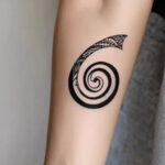 Golden spiral tattoo on the upper arm