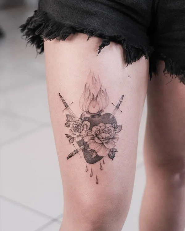 Burning heart tattoo on the thigh, by @sashatattooing, symbolizing passion and intensity