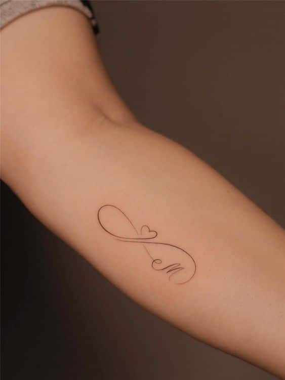 Minimalist infinity tattoo with a heart and letter 
