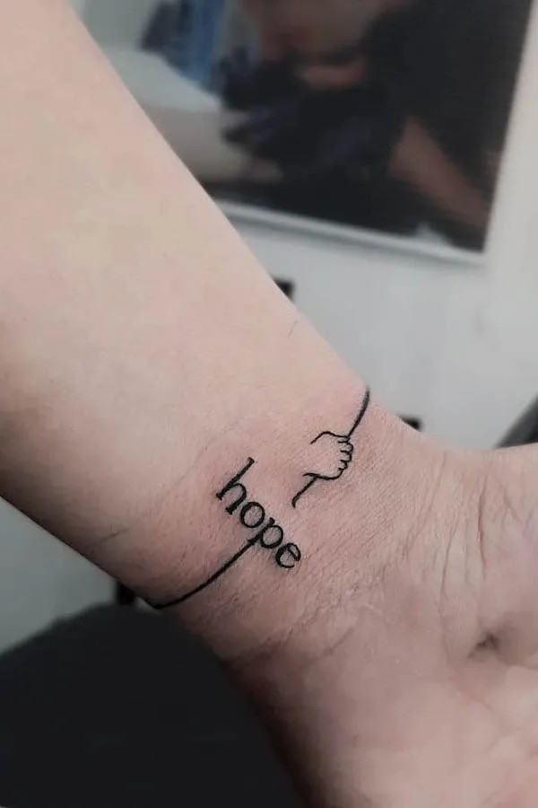 Delicate hope one-word tattoo for women by @soji_tattoo
