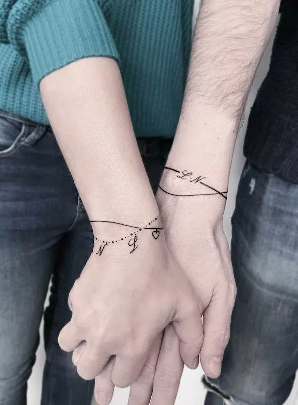 Matching initial bracelet tattoos for couples by @danielapiantoni1928