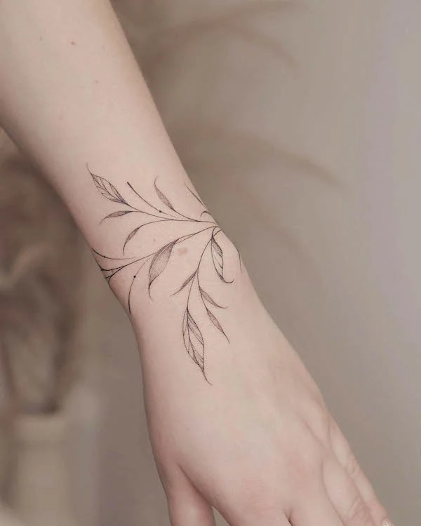 Minimalist leaves bracelet tattoo by @monochrom.ink