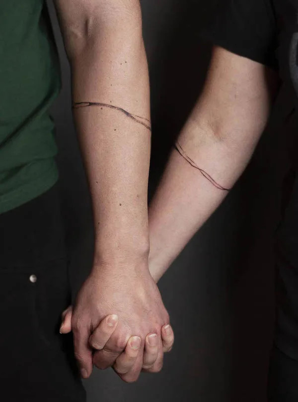 Matching single line bracelet tattoos for couples by @meester_prikkebeen