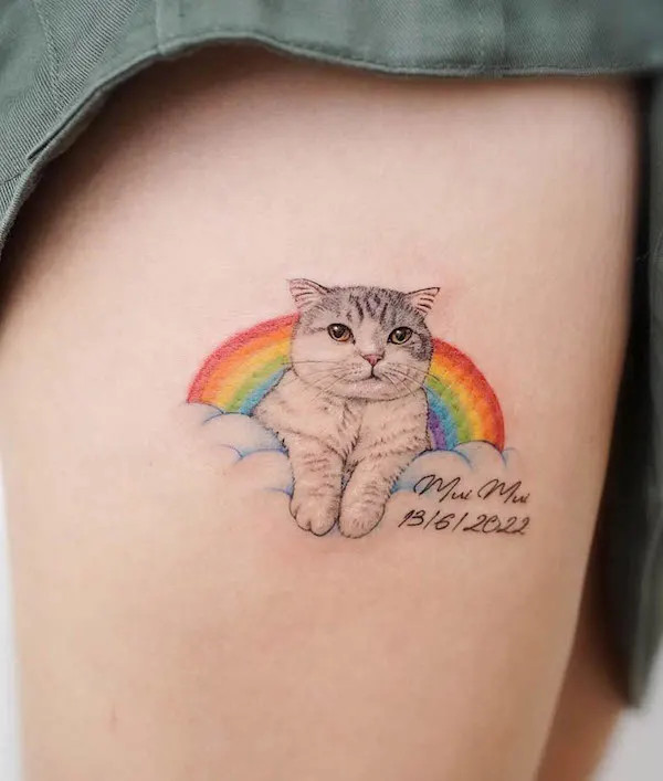 Cute rainbow and cat tattoo on the thigh, by @hktattoo_ying24, symbolizing joy and companionship