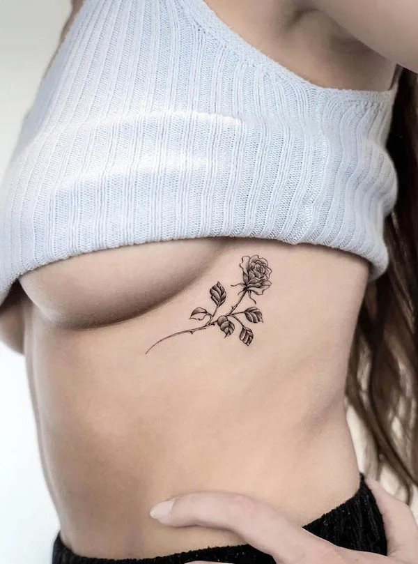 Minimalist flower rib tattoo by @jk.tattoo