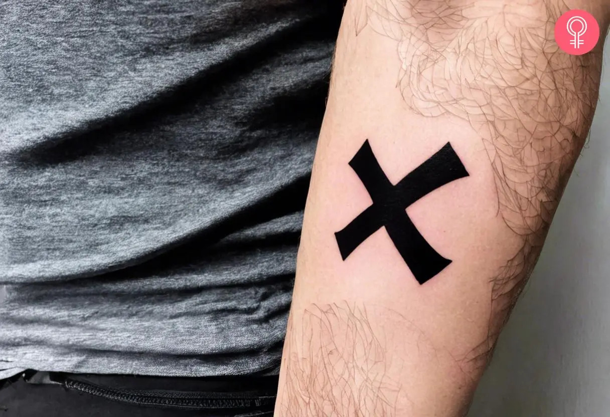 One Piece X tattoo on a woman’s forearm