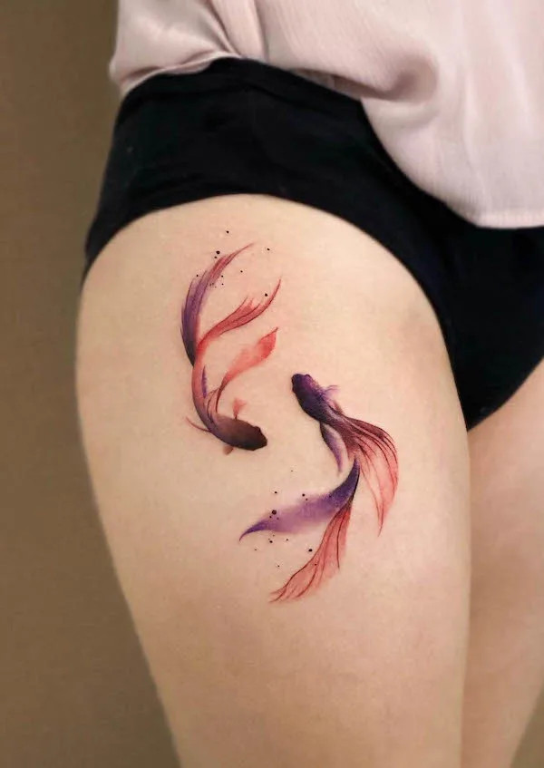 Pisces fish tattoo on the thigh, by @leean.ink_, representing duality and fluidity