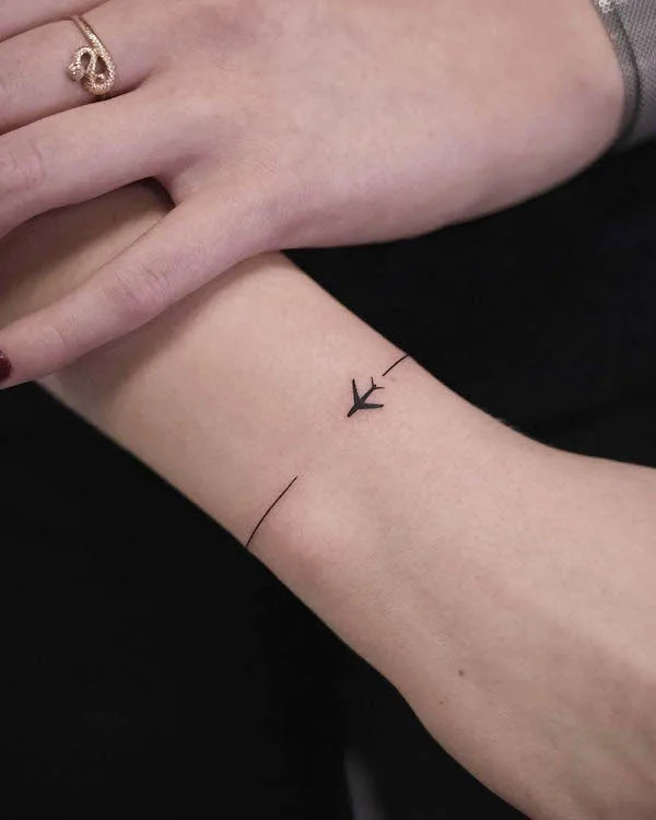 Tiny plane bracelet tattoo for travel lovers by @blueberry_ink