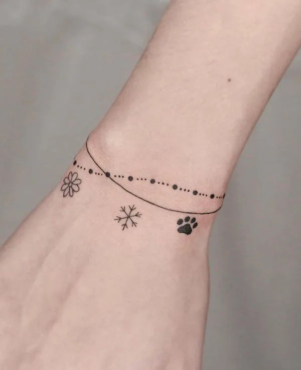 Cute small symbols bracelet tattoo for women by @tattooer_ian