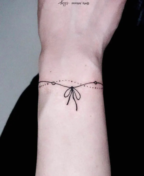 Elegant ribbon bracelet tattoo for women by @elly_tattooist