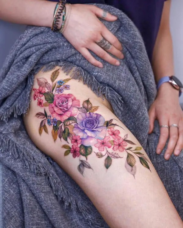 A vibrant assortment of beautiful flowers tattooed on the thigh, by @tattooist_silo, showcasing nature's elegance