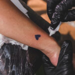 Tattoo artist wiping a tattoo