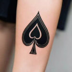 A woman with a minimalist ace of spades tattoo on her arm