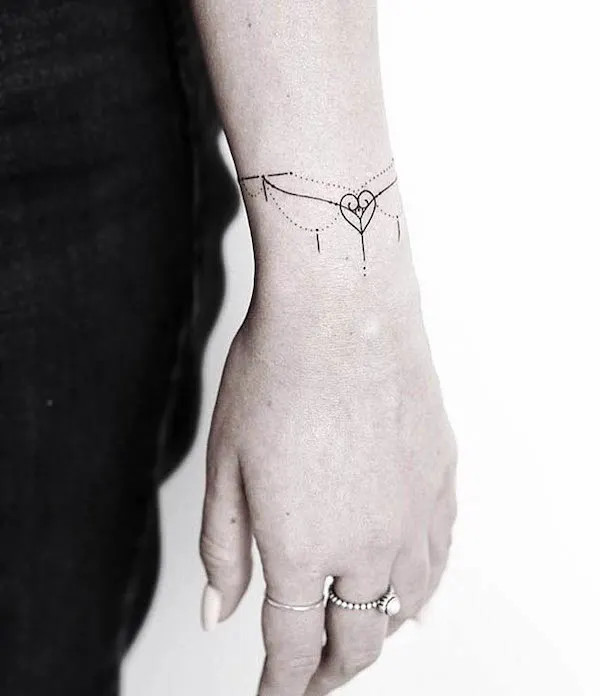 Understated simple heart shape pendant bracelet tattoo for women by @lagrainetattoo