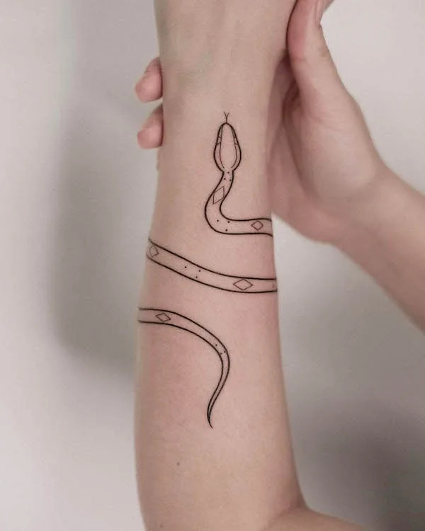 Sleek simple snake bracelet tattoo for women by @harmony.ttt
