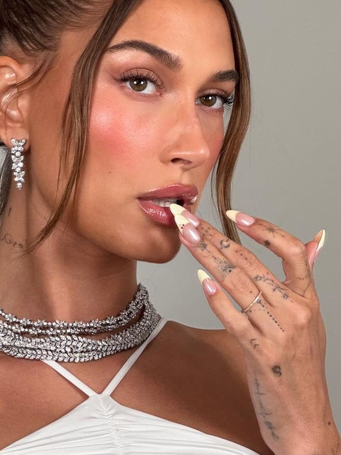 Hailey Bieber's hand tattoos exemplify the chic subtlety of dainty tattoo designs, perfect for those seeking understated elegance.